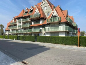 A multi-story building with a traditional architectural style, featuring balconies and a red-tiled roof. - Apartment in Nieuwpoort Near Flemish Coast (Nieuwpoort)