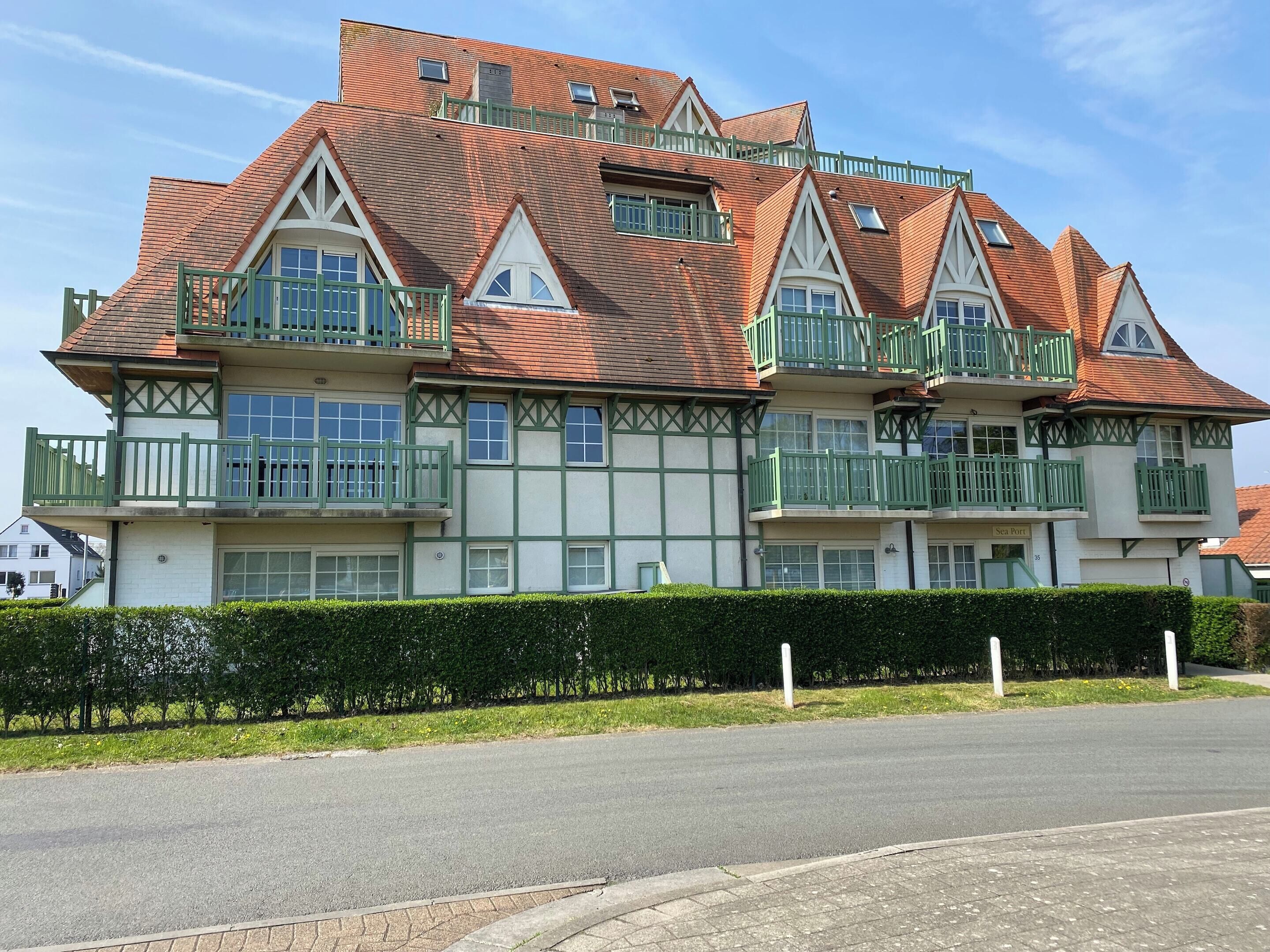 A large, multi-story building with a traditional architectural style, featuring multiple balconies and a brick facade.