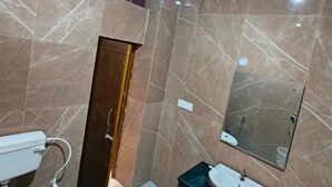 Een moderne badkamer met toilet, wastafel en spiegel.