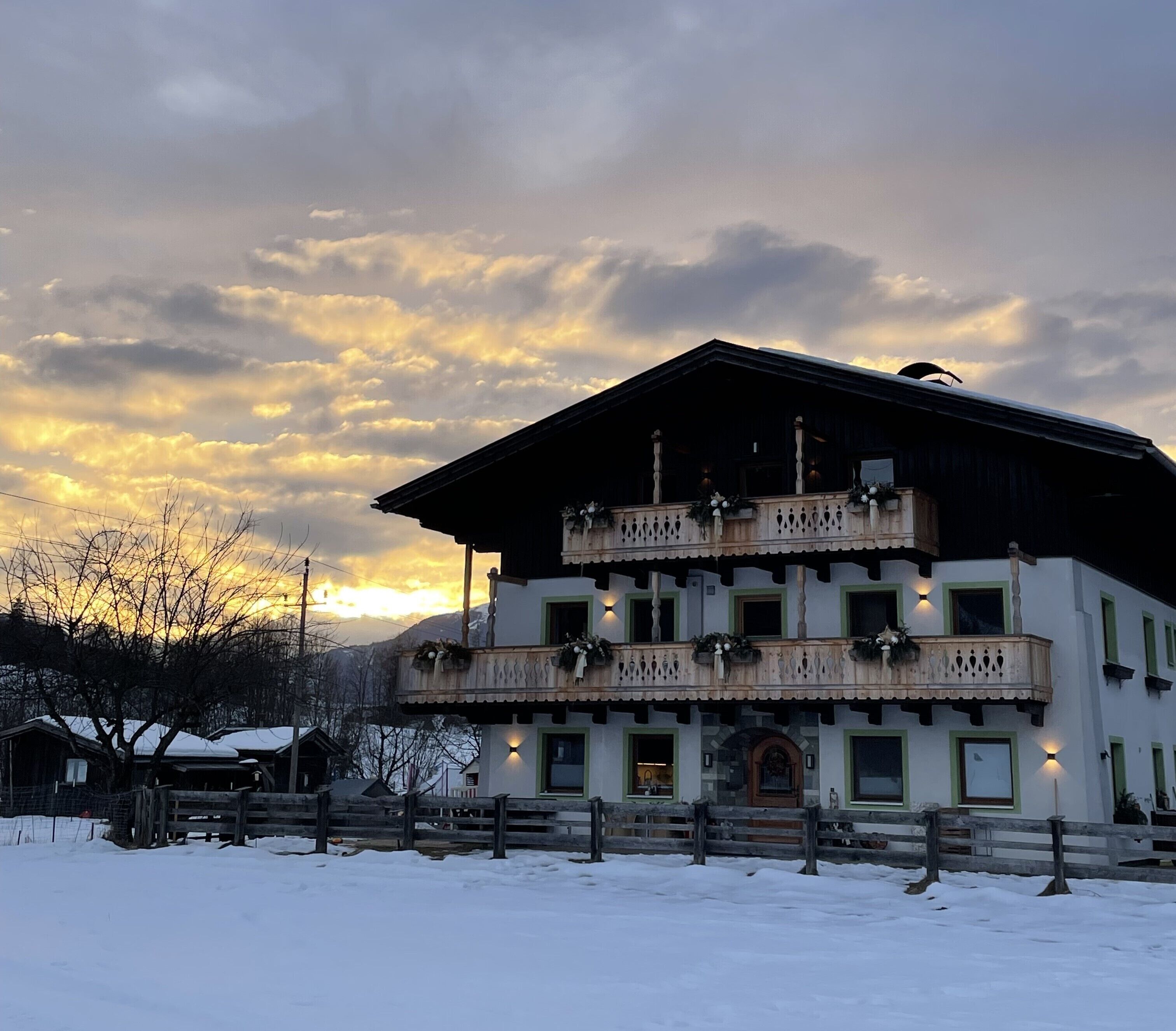 Un edificio de dos pisos con balcón, rodeado de nieve.