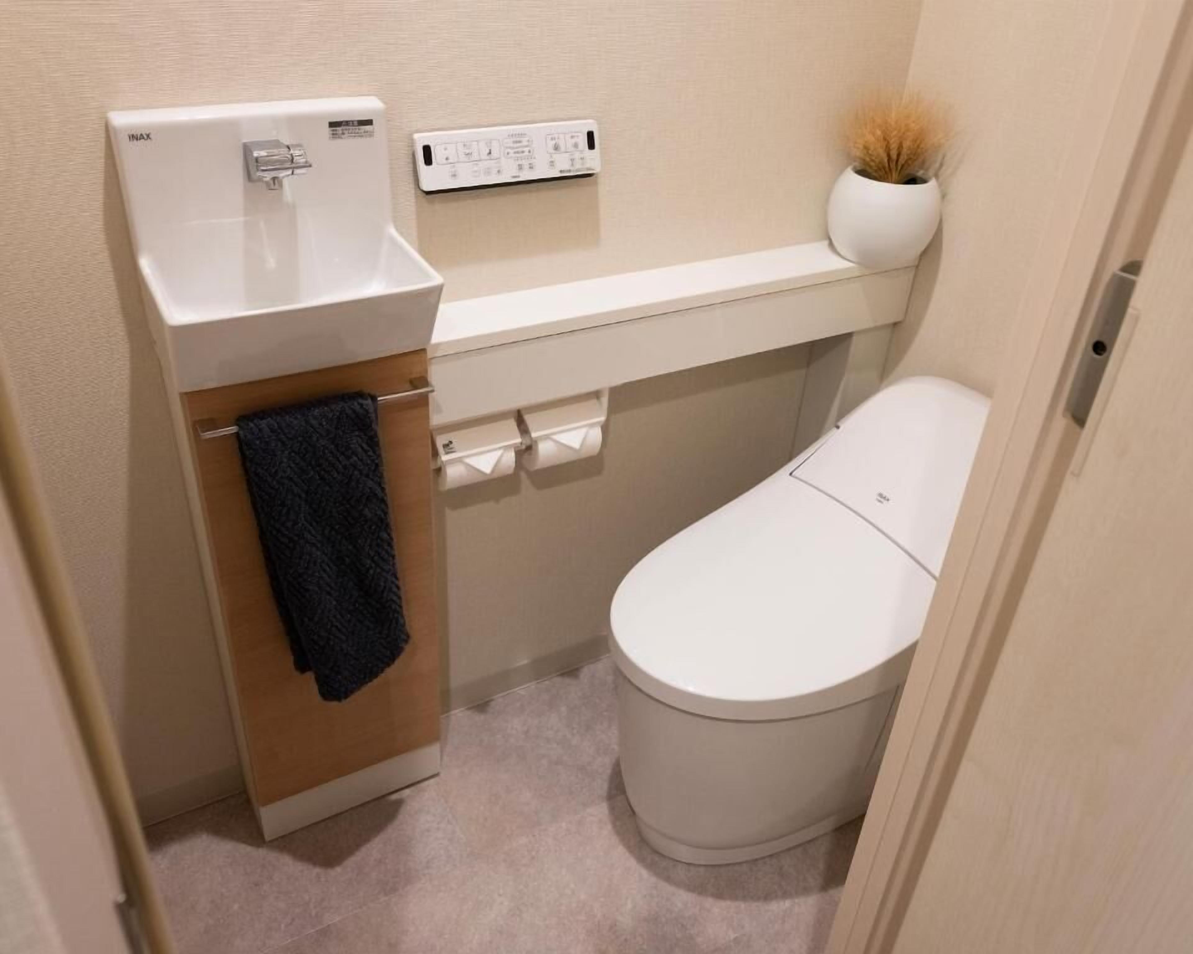 A small, clean bathroom with a toilet, a sink, and a towel rack.