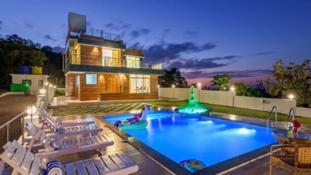 A modern two-story house with a swimming pool, lounge chairs, and a fountain. - Tranq Villa by Stay Serene Luxury (Murbad)