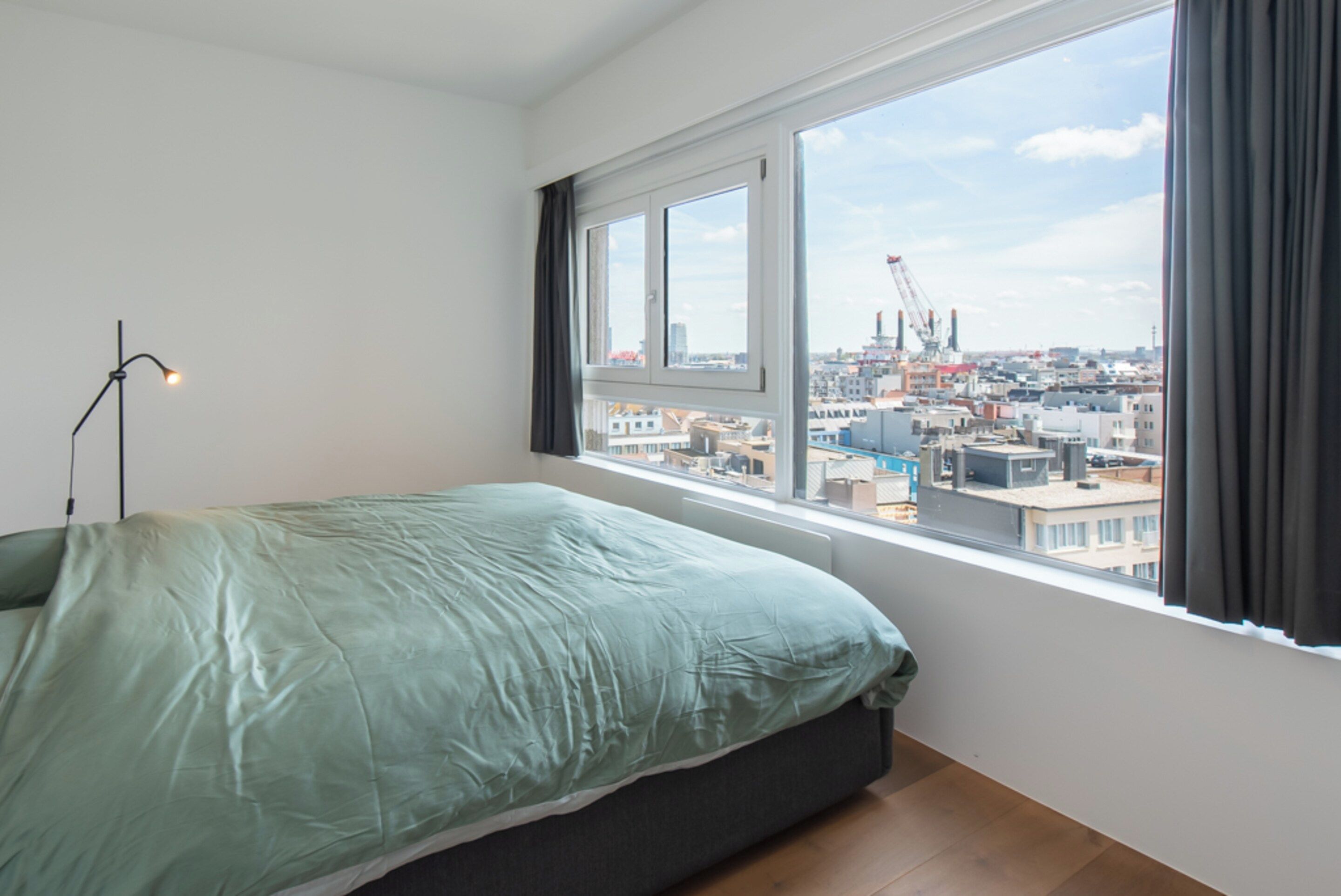 Una camera da letto con un letto, una finestra e vista sulla città.