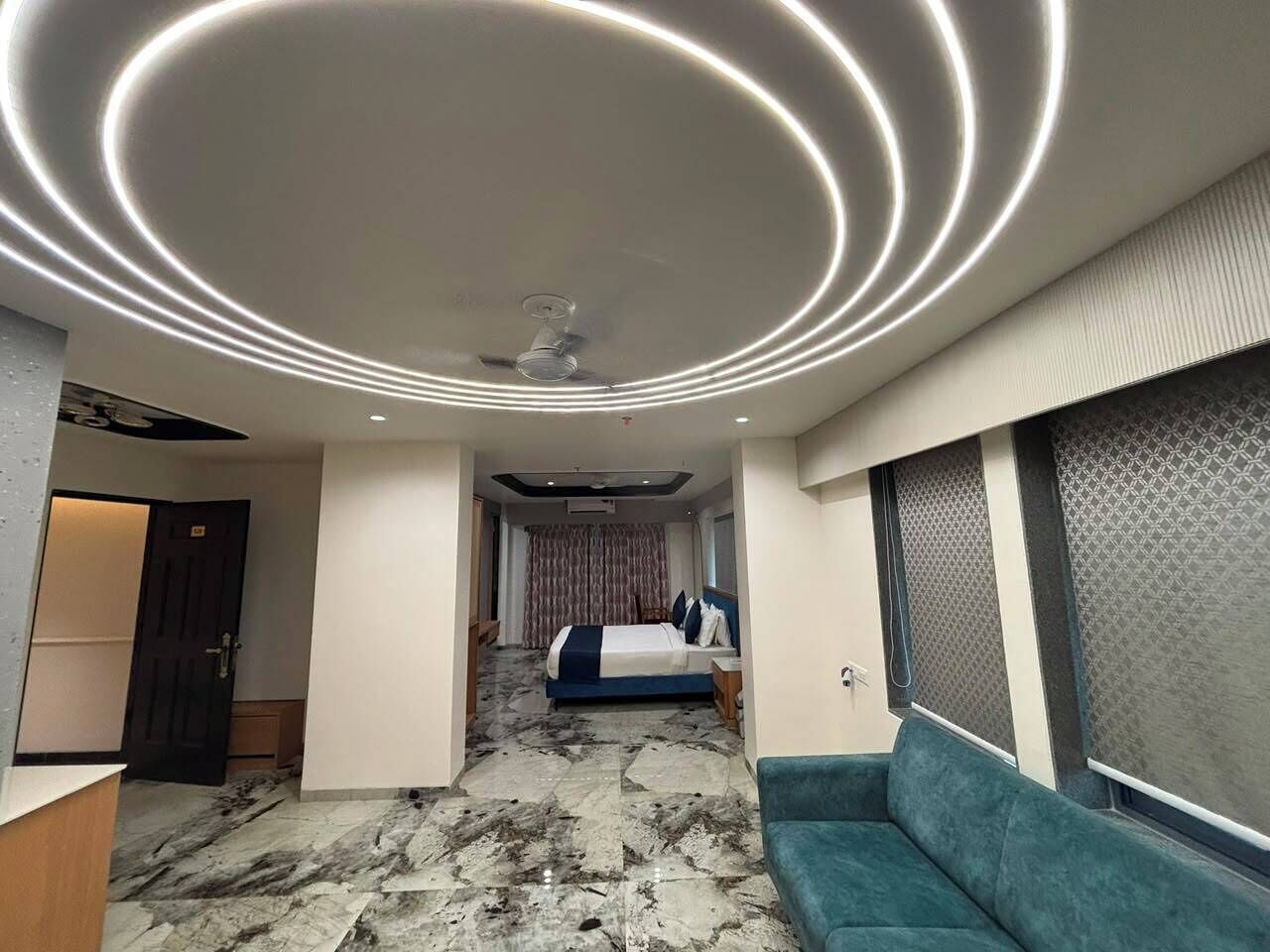 A hotel room with a bed, a seating area, and a reception desk.