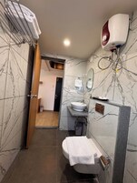 Un baño con inodoro, lavabo y perchero para toallas.