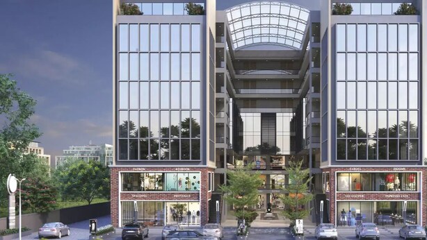 A modern multi-story building with large glass windows and a central atrium. - Hotel Royal Galleria (Vadodara)