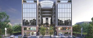 A modern multi-story building with large glass windows and a central atrium. - Hotel Royal Galleria (Vadodara)