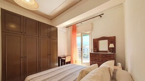 Ein Schlafzimmer mit einem großen Bett, einem Kleiderschrank, einem Schreibtisch und einer Kommode.