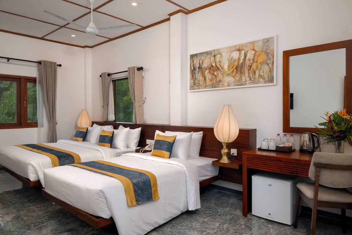 Habitación triple Deluxe, balcón, vistas al jardín | Caja fuerte, escritorio, cortinas opacas y tabla de planchar con plancha