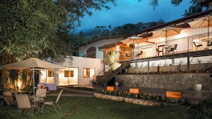 A modern house with a patio area, outdoor seating, and a stone wall. - Mirage Kandyan Heights (Kandy)