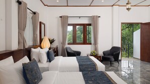 A hotel room with a large bed, two chairs, a small table with a vase, and a window with curtains. - Mirage Kandyan Heights (Kandy)
