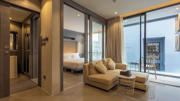 A modern hotel room with a sofa, a small table, and a bed. - FullyLoadedBestFacilitiesNicestAptc141 (Kamala)