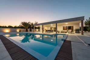 A modern outdoor pool area with a patio, seating, and a covered section. - Villa Olea Pridraga Zadarvillas (Novigrad)