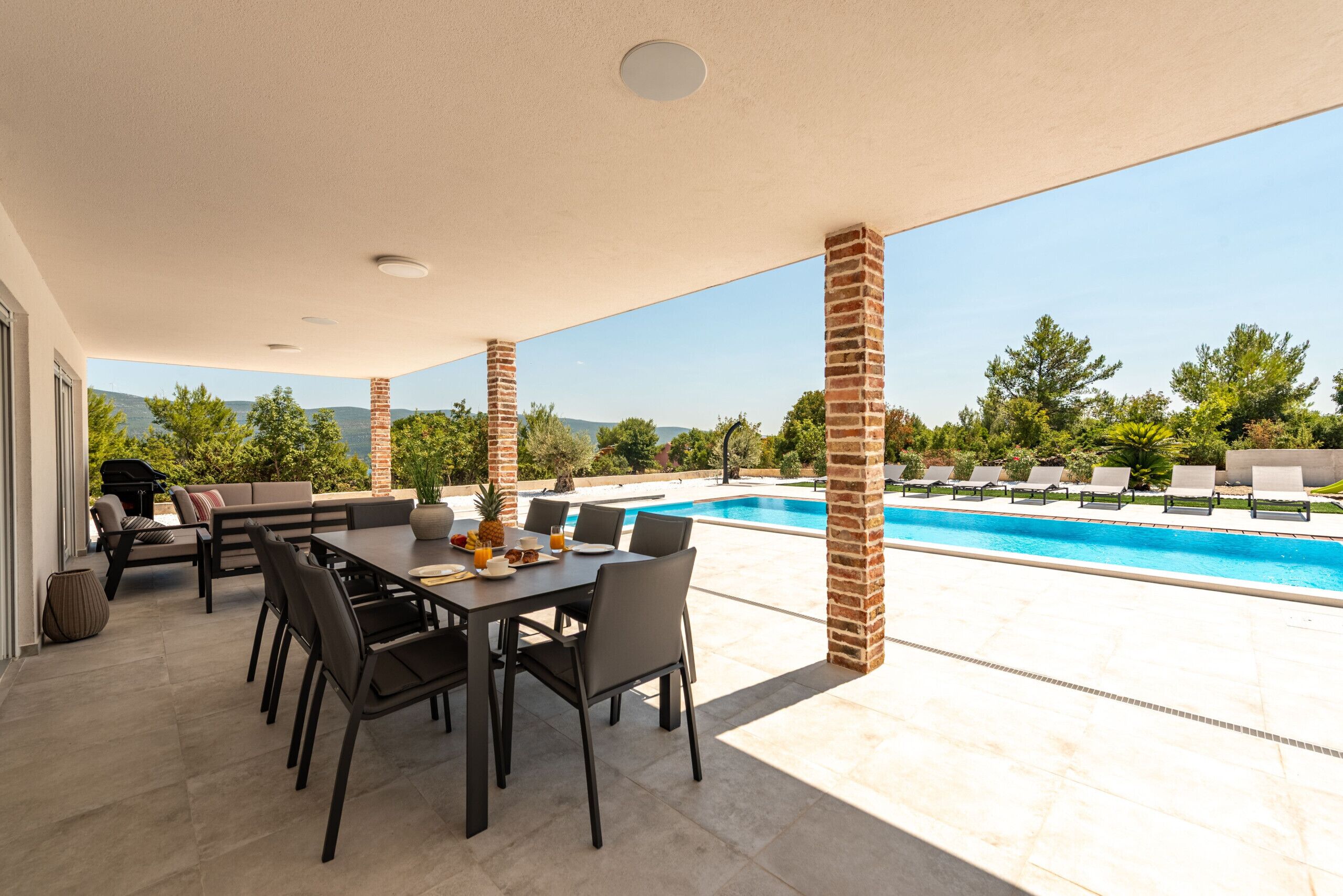 An outdoor patio with a pool, dining area, and lounge chairs.