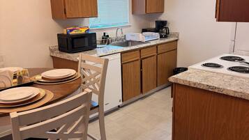 A kitchen with wooden cabinets, a microwave, a toaster, and a dishwasher.