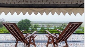 A balcony with two wooden chairs and a patterned ceiling. - Shamiyana by Stay Serene Luxury (Murbad)