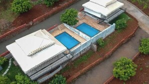 A building with a swimming pool and a covered area, surrounded by greenery. - Shamiyana by Stay Serene Luxury (Murbad)