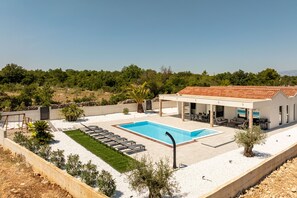 A modern house with a swimming pool, outdoor seating, and a view of the surrounding landscape. - Villa Olea Pridraga Zadarvillas (Novigrad)
