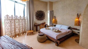Une chambre avec un grand lit, un bureau et une chaise. Il y a une fenêtre avec des rideaux et un paravent décoratif.