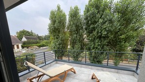 A balcony with two lounge chairs and a metal railing. - "Villa LOM: 800m from the beach (Asnelles)
