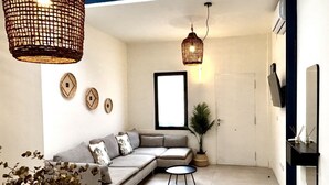 A modern living room with a sectional sofa, a small round table, and a potted plant.