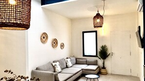 A modern living room with a sectional sofa, a small round table, and decorative wall art.