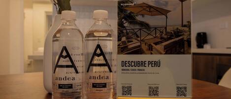 Two bottles of 'andea' water and a QR code stand with a photo of a terrace.