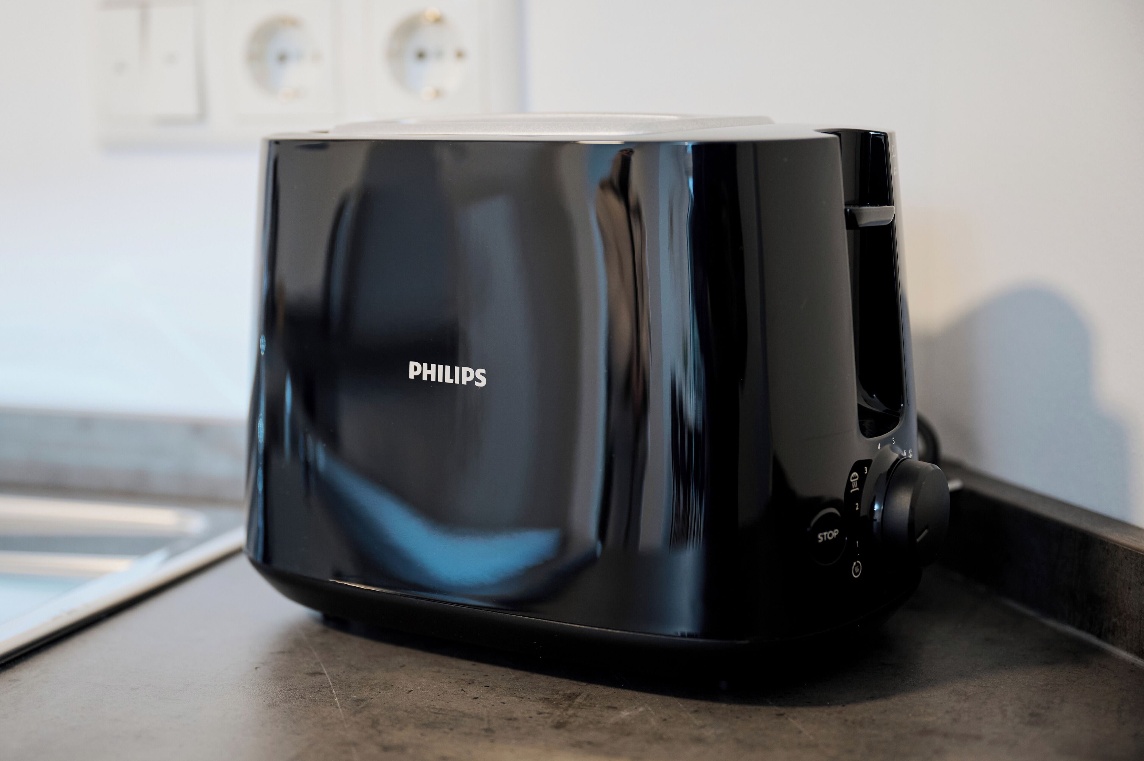 Un torradora Philips negre sobre una superfície de cuina.