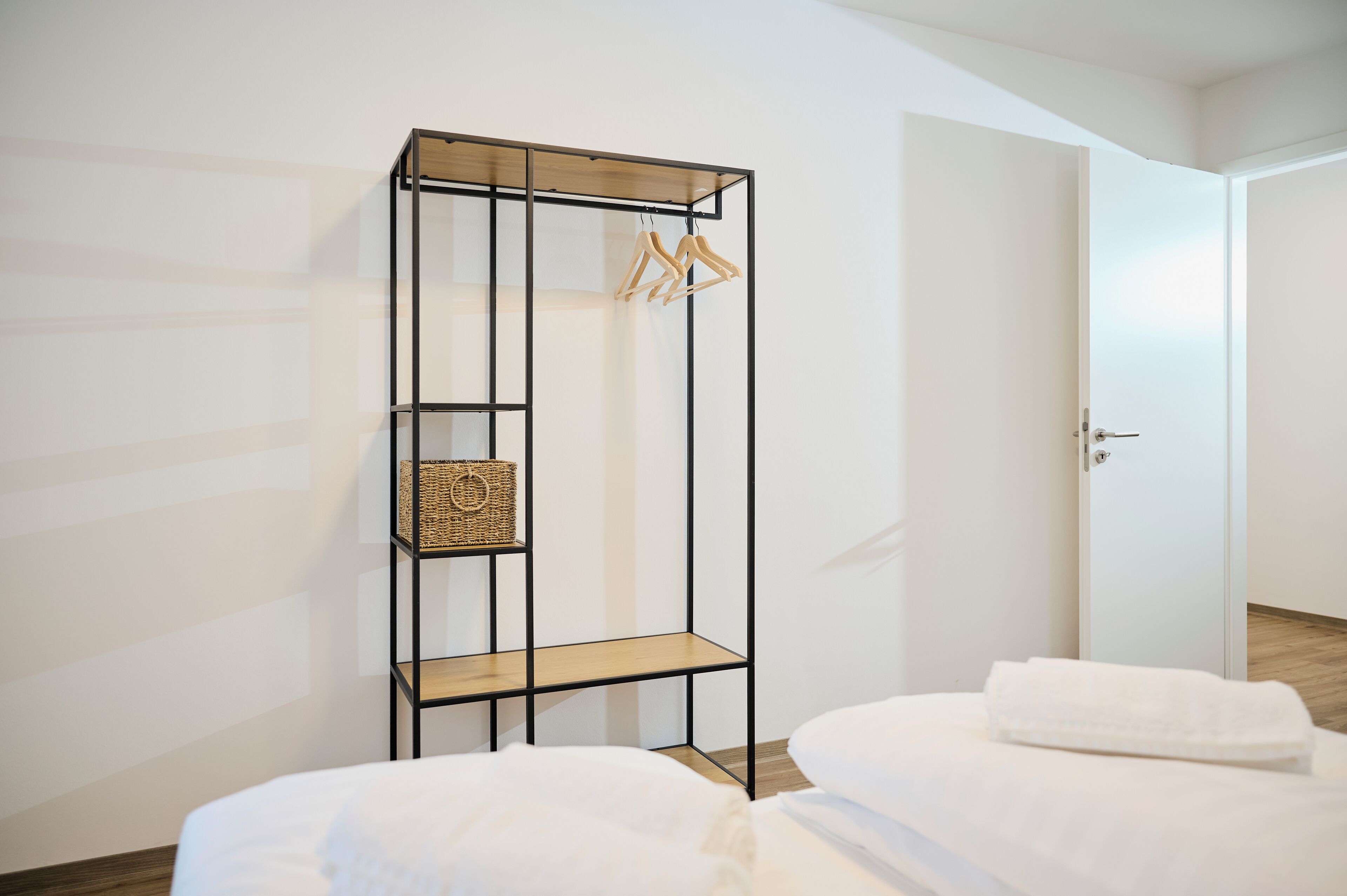 Un dormitorio con cama, armario y puerta.