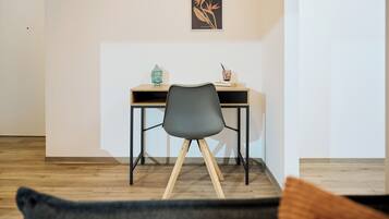 A modern room with a desk, chair, and a framed artwork on the wall.