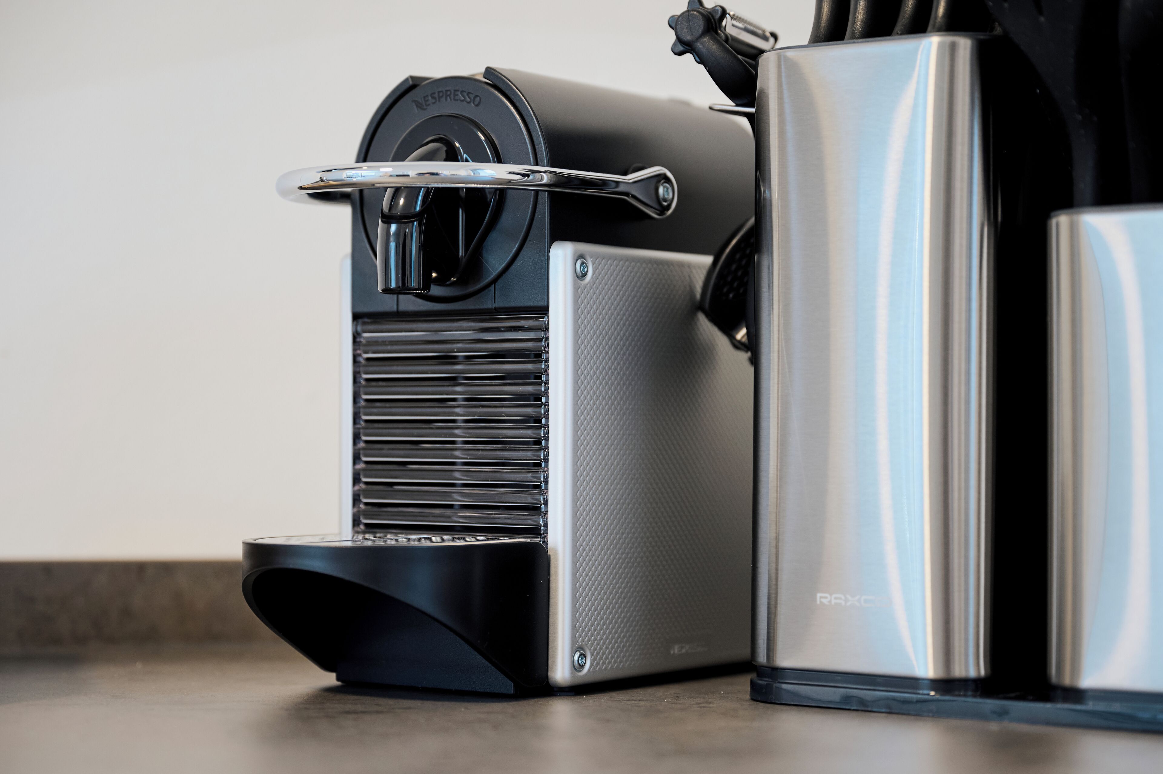 A coffee machine with a metallic finish and a control panel.