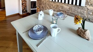 Una cocina moderna con una pared de piedra, una mesa de comedor con vajilla blanca y azul, y un adorno en la pared.