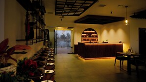 Een restaurant met een lange toonbank, een bar en een wenteltrap met planten.