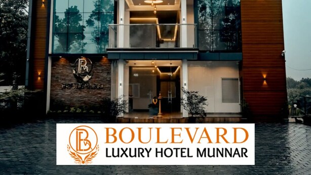 Een luxe hotel met meerdere verdiepingen en een modern ontwerp, met een opvallend logo en naam op de gevel.