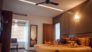 Een moderne slaapkamer met een groot bed, een houten hoofdbord en een plafondventilator.