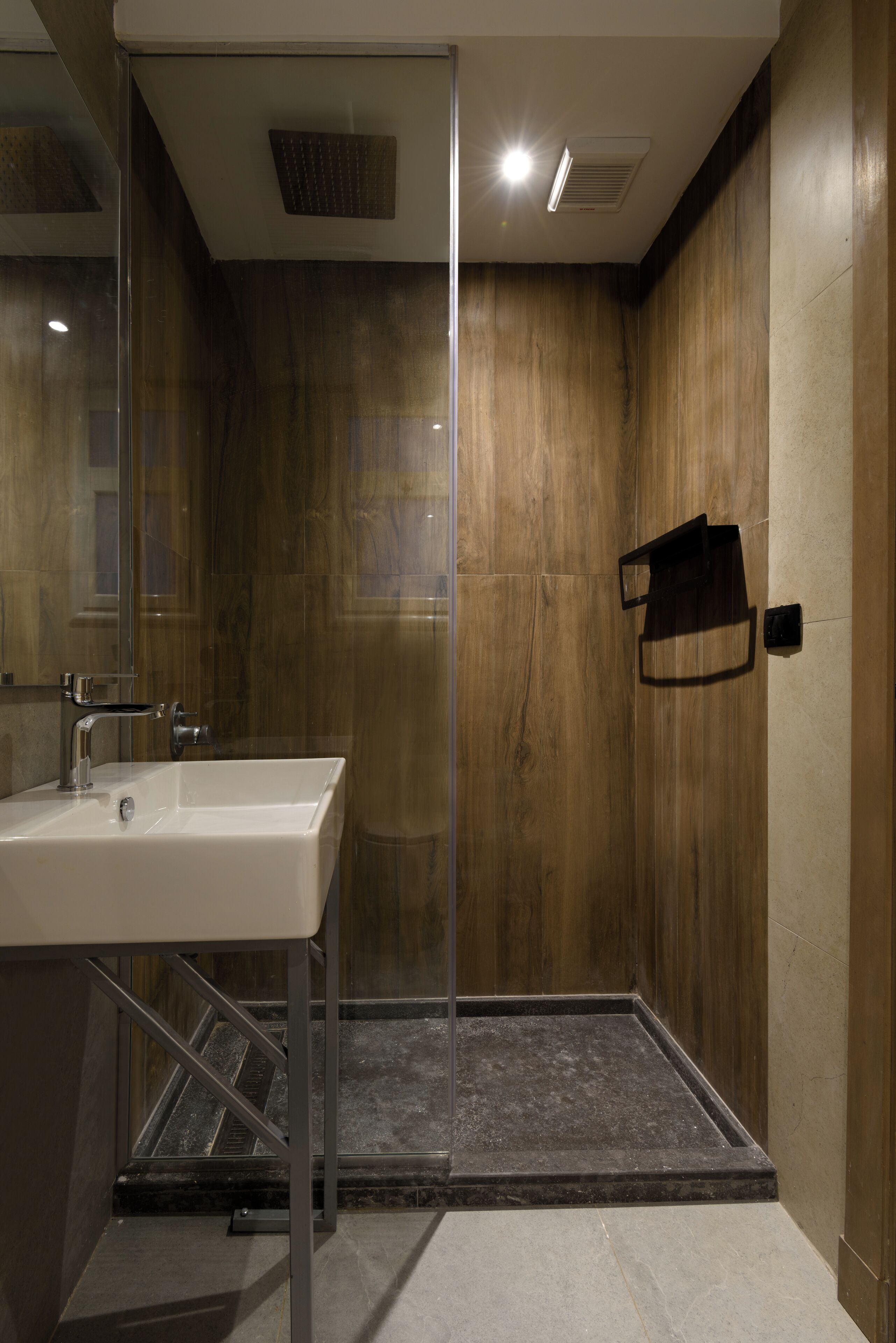 Une salle de bain moderne équipée d’une douche, d’un lavabo et d’un porte-serviettes.