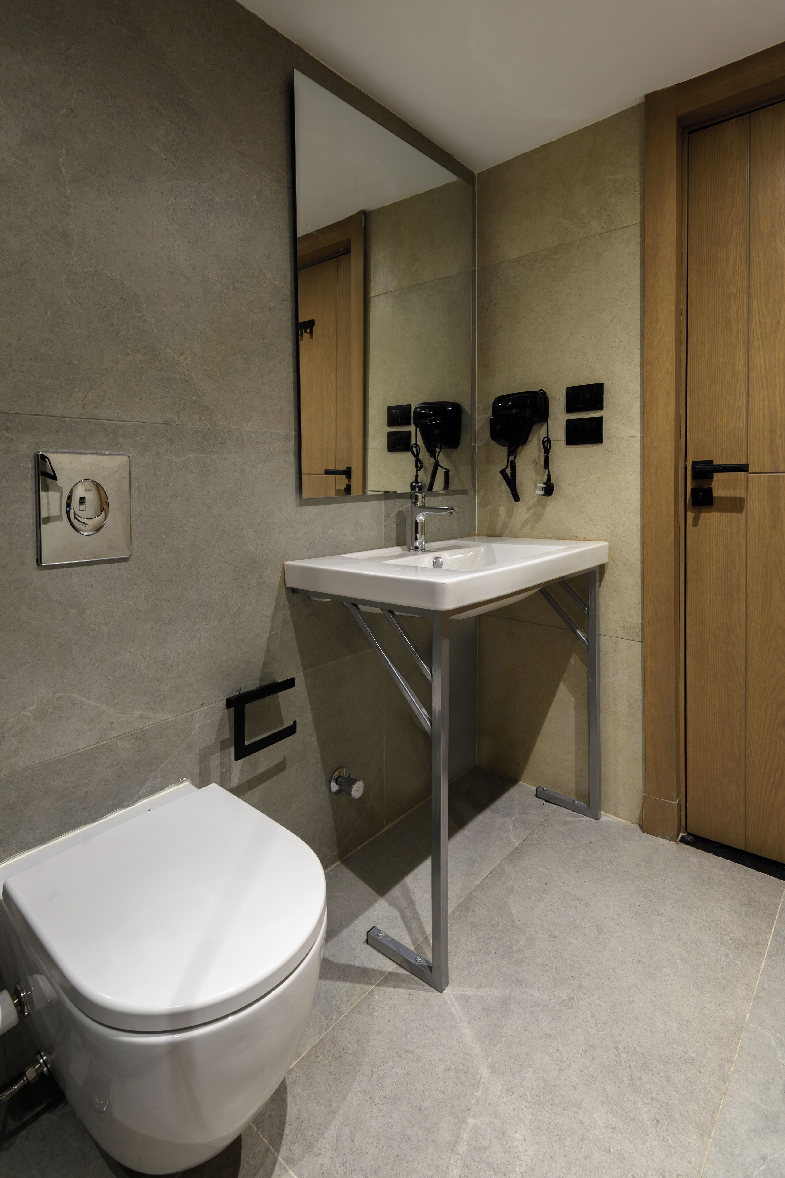 A modern bathroom with a white toilet, a sink, and a mirror.