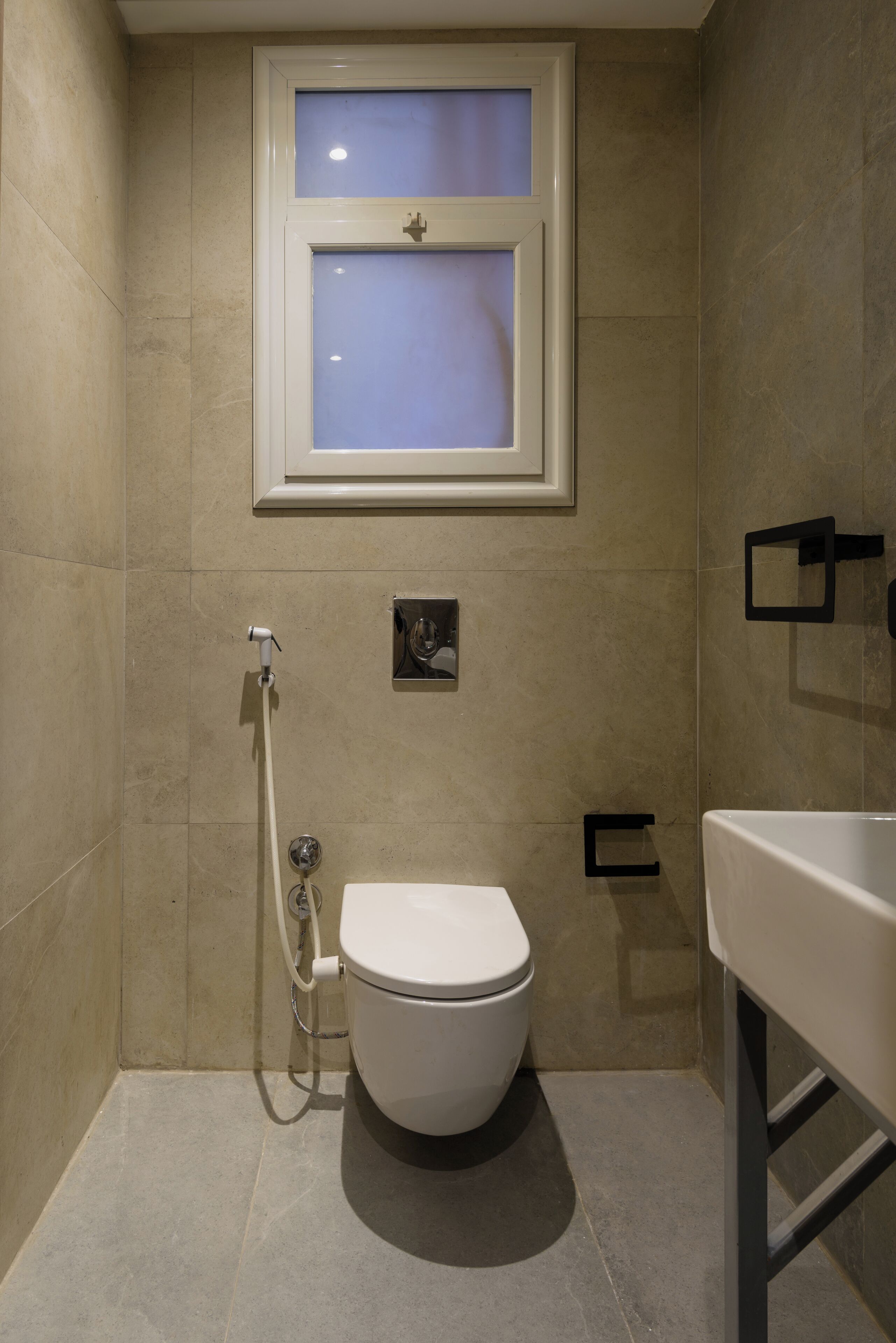 A bathroom with a toilet, a shower, and a window.