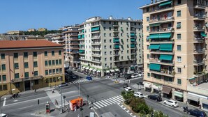 A multi-story building with balconies, a crosswalk, and parked cars. - Corso Sardegna Design Apartment by Wonderful Italy (Genoa)