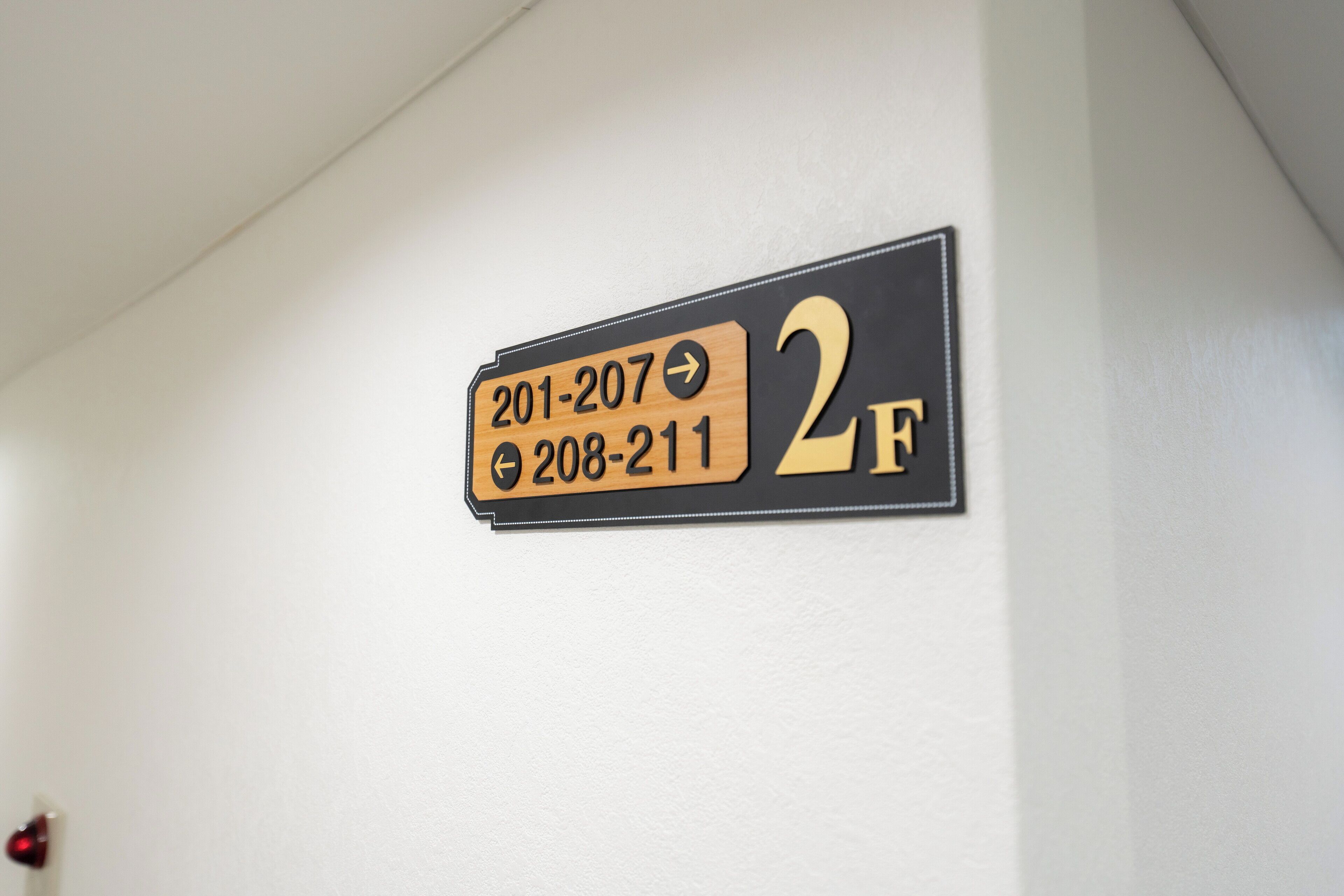 A wall-mounted sign with room numbers and directional arrows.