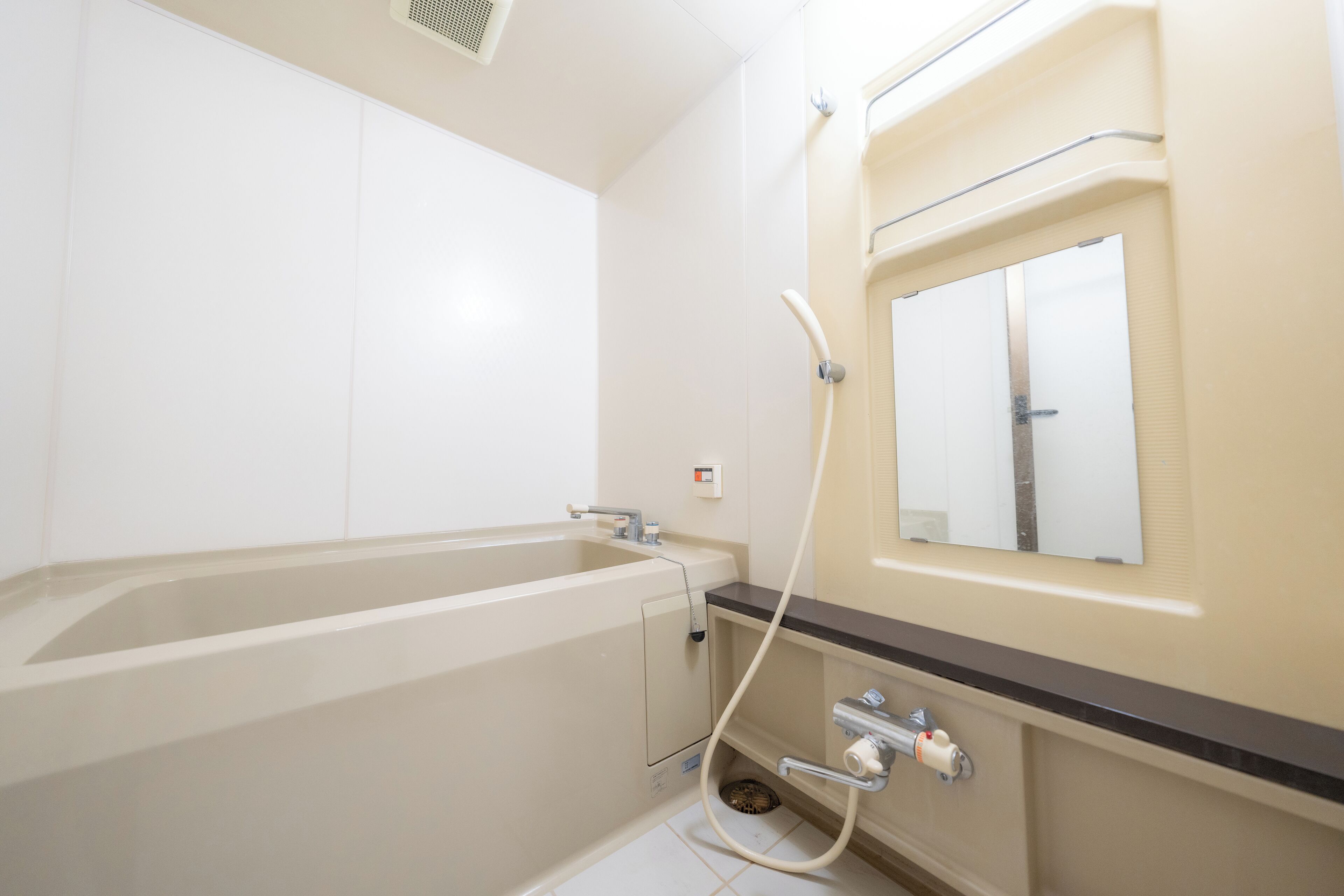 A bathroom with a bathtub, a shower, and a mirror.