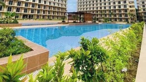 A residential building complex with a swimming pool. - Studio w Pool, Mountain & City View Mactan Airport (Lapu-Lapu)