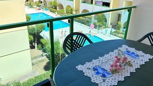 A balcony with a view of a swimming pool and adjacent buildings. - Apartment With Pool View-beahost (San Michele al Tagliamento)