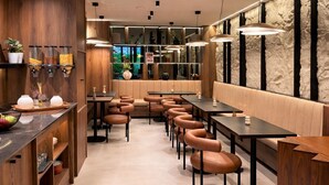 A modern restaurant interior with wooden paneling, leather seating, and pendant lighting.