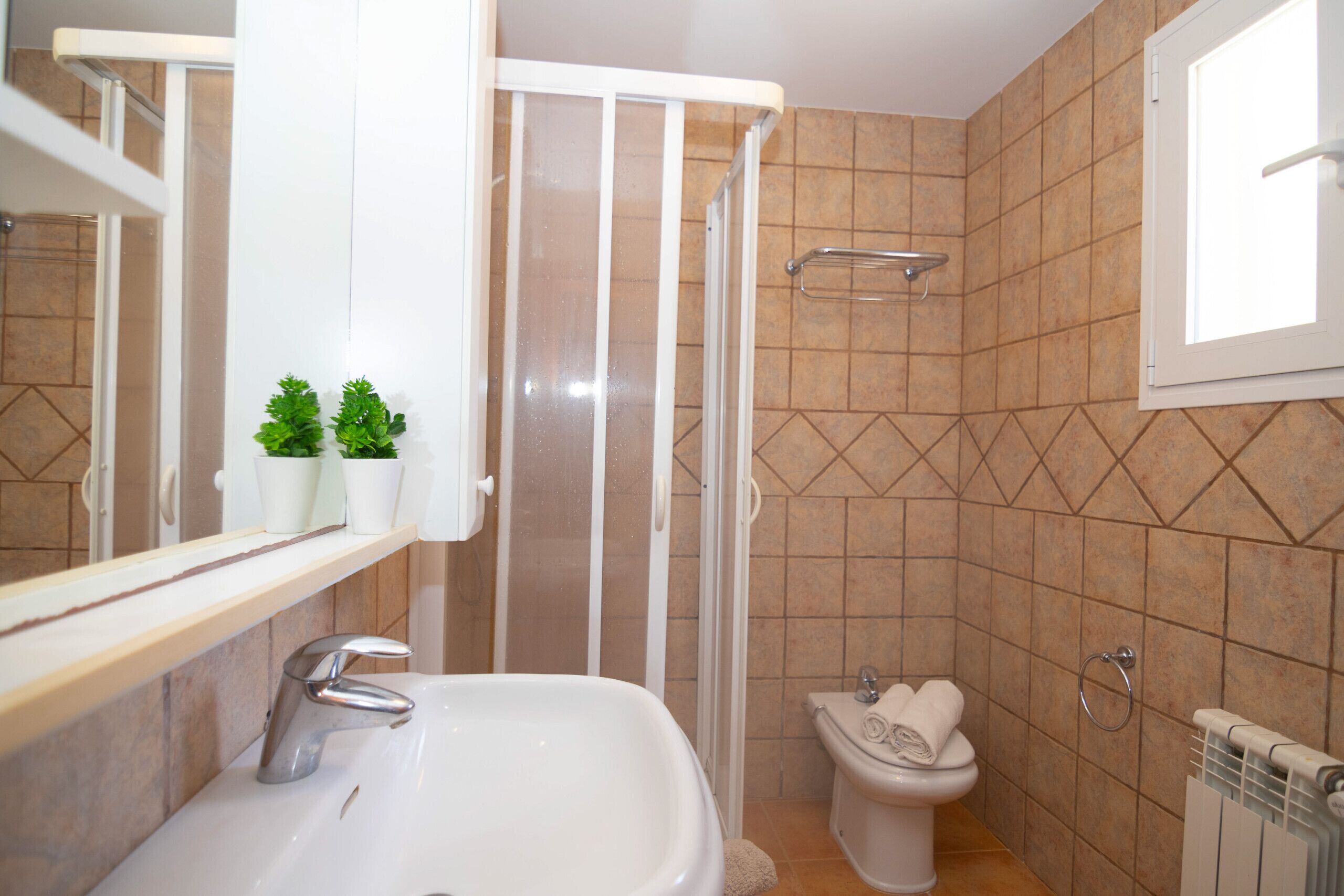 A bathroom with a sink, toilet, and shower.