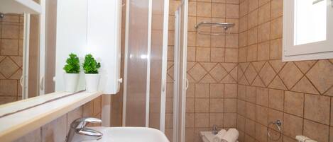 A bathroom with a sink, toilet, and shower.