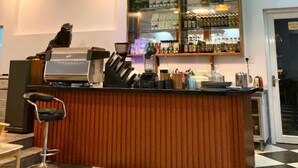 A bar area with a wooden counter, hanging pendant lights, and a bar display. - ML Homestay (Ho Chi Minh City)