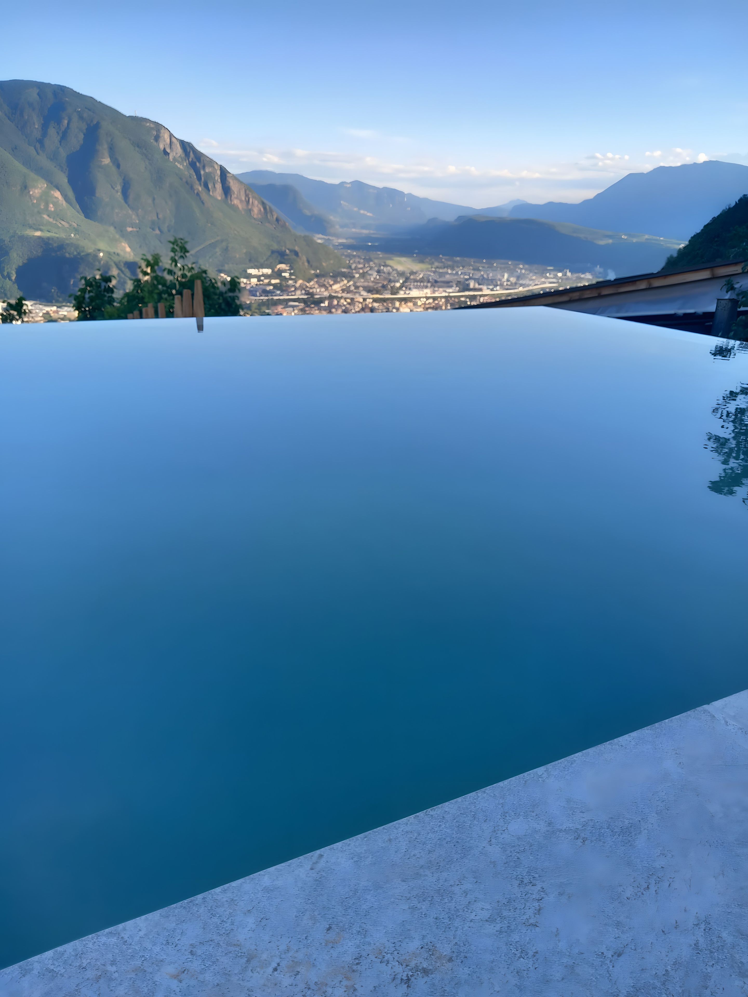 An infinity pool with a clear view of a cityscape and mountains in the background.