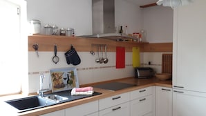 Eine Küche mit Spüle, Arbeitsplatte und verschiedenen Küchenutensilien an der Wand.