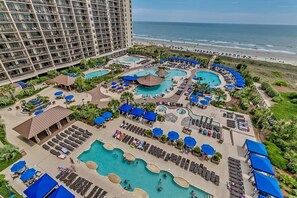 A resort with multiple swimming pools, sun loungers, and umbrellas. - Beachfront Bliss: Discover Paradise in Our Luxurious 2-Bedroom Condo with Ocean Views! (North Myrtle Beach)